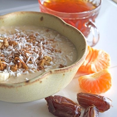 overnight oatmeal in a bowl made with coconut crush chai tea surrounded by oranges and dates