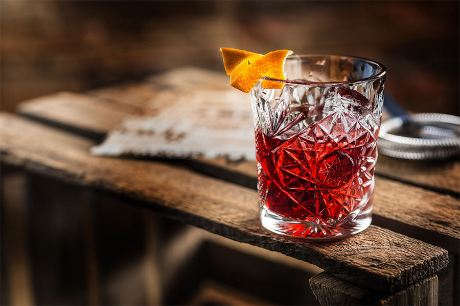 a glass with a red tea mocktail sits on a wooden table