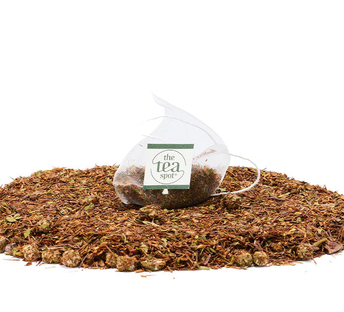 
                  
                    a tea bag sits atop a pile of loose leaf tea, the tea is a rooibos herbal blend with marshmallows
                  
                