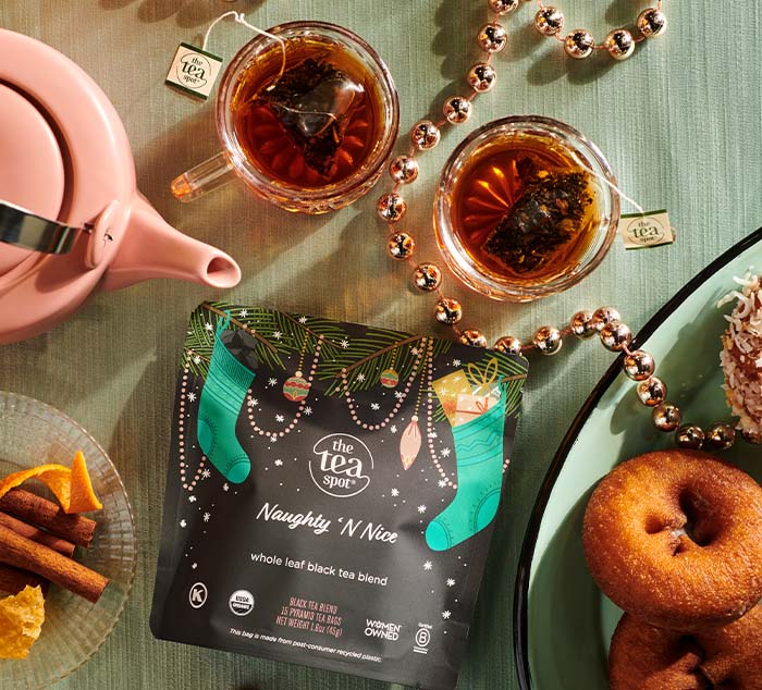 a bag reading naughty n nice whole leaf black tea blend sits on a table set for breakfast