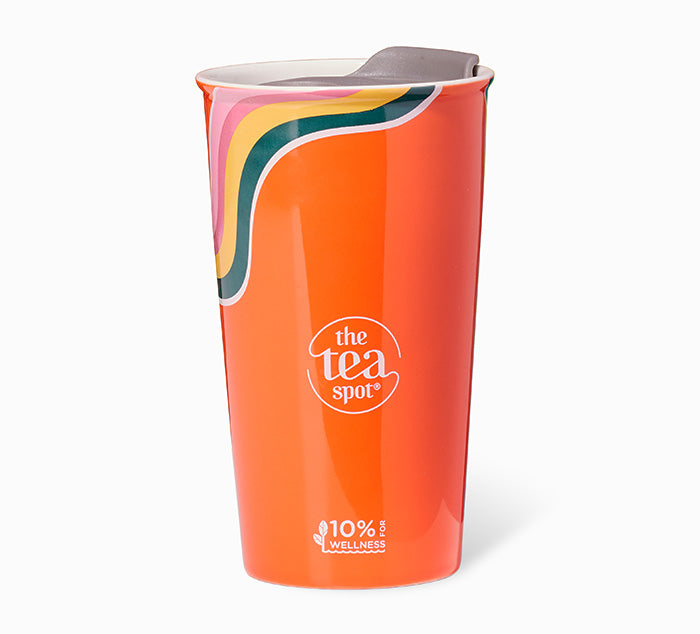 orange ceramic mug with rainbows and a grey lid with a tea spot logo in the middle