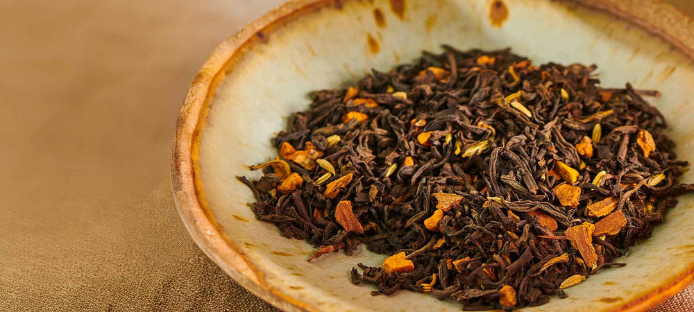 rise and chai loose leaf tea sits in a bowl on a brown tablecloth