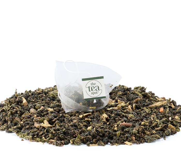 
                  
                    Single Sugar Cookie Oolong tea bag resting on a pile of loose tea leaves against a white background
                  
                